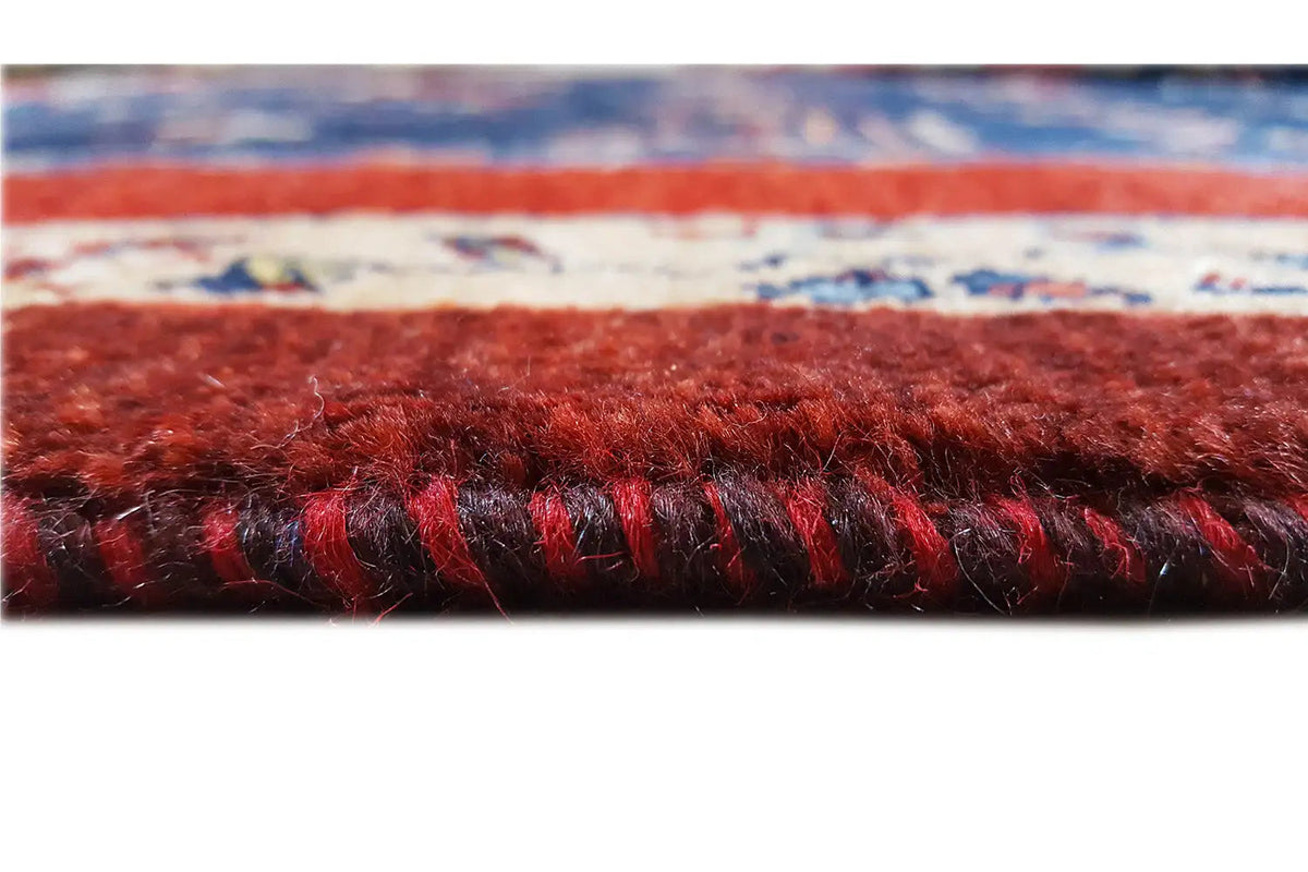 Carpet edge in detail: dense pile, red stripe, and short fringe