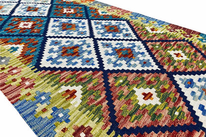 Details of the kilim runner: light blue diamonds, green and red floral motifs, multicolored