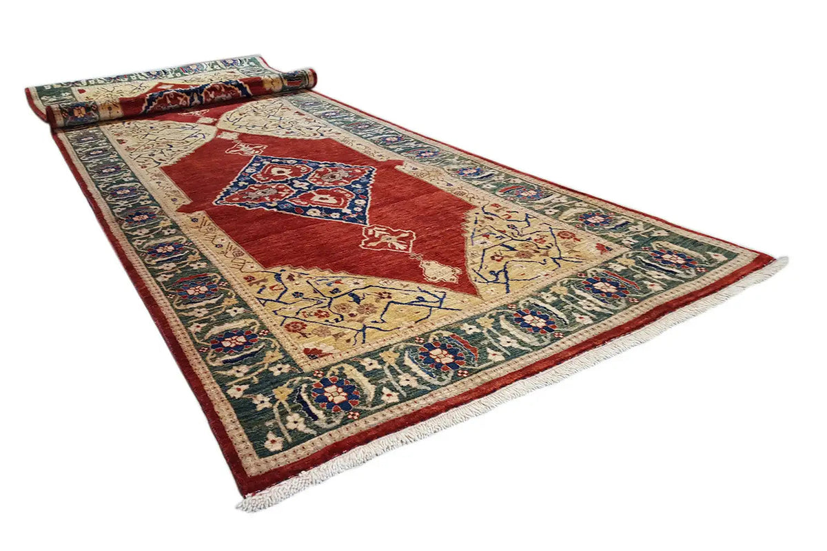 Oriental rug spread out: red center with stepped ornaments and border