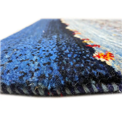 Close-up: blue carpet pile and edge with a dark border and multicolored trim