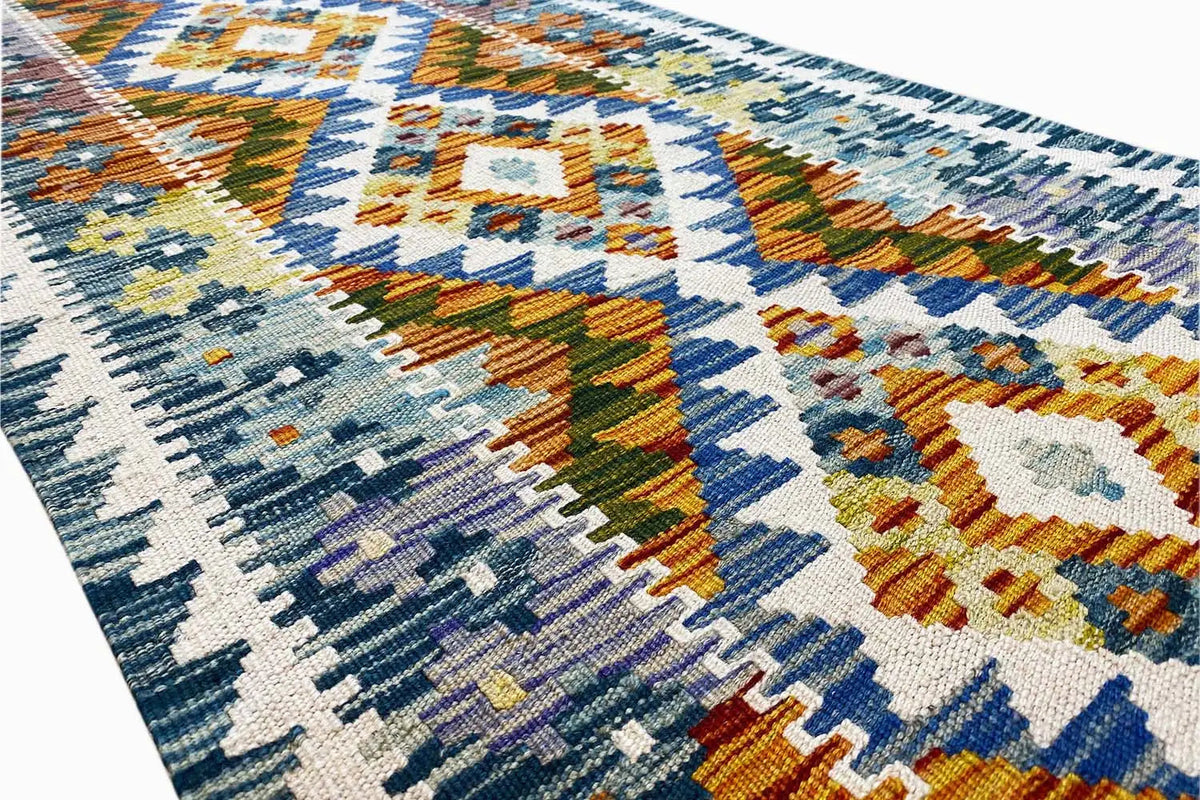 Kilim runner: Detail of the woven pattern with diamonds in blue, orange, and green.