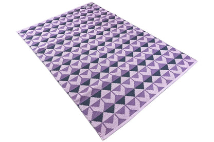 Folded kilim with purple, light, and dark triangular diamonds in a geometric pattern