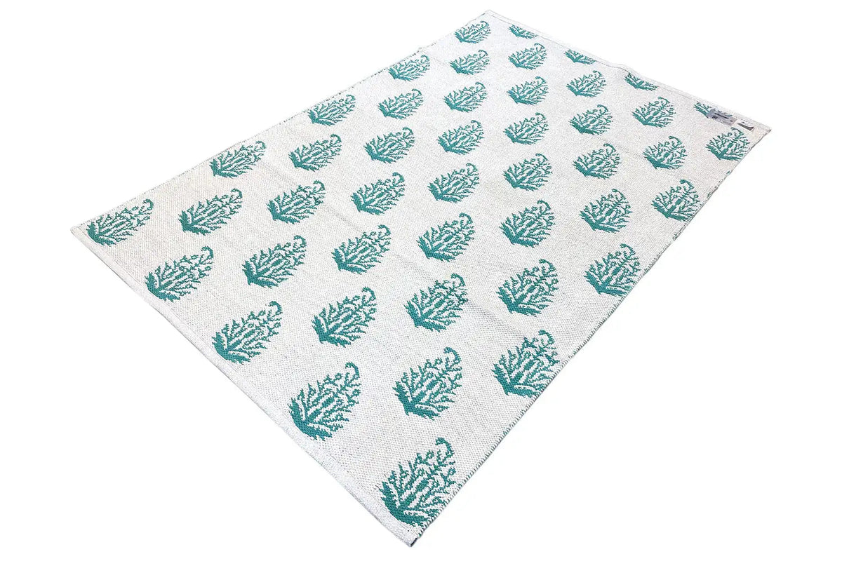 Modern kilim rug with a beige background and turquoise tree pattern, diagonal