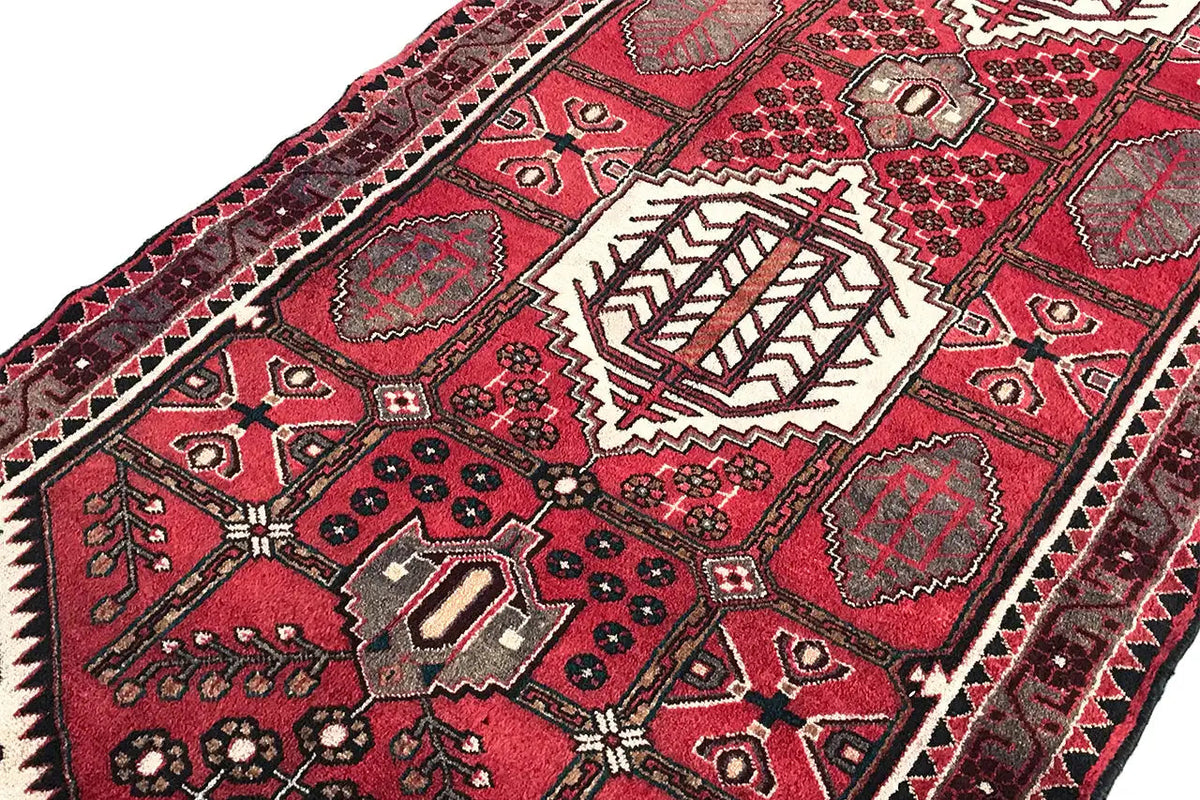 Pattern detail on the Hamadan runner with a red background, white medallions, and zigzag ornaments