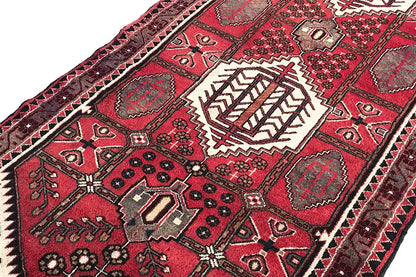 Pattern detail on the Hamadan runner with a red background, white medallions, and zigzag ornaments