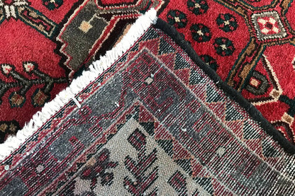 Hamadan runner close-up: bound edge and gray diamond ornament in the red field