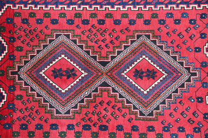 Oriental rug with a red ground, blue and white ornaments, corner medallions, and a decorative border