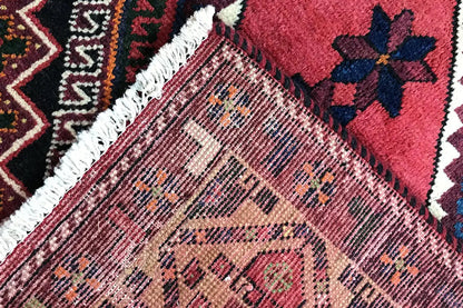 Carpet edge with white fringe and a dense pattern of red, blue, and yellow areas