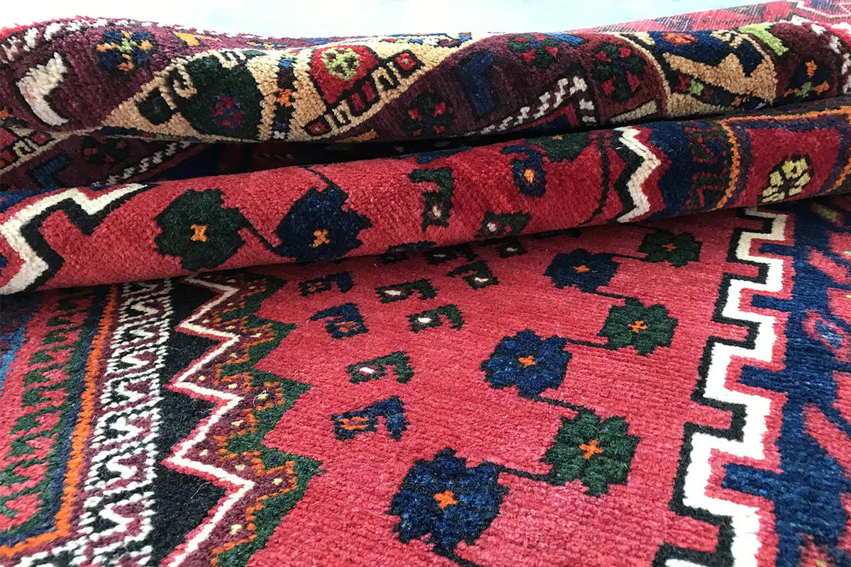 Rug with a wavy surface: red center, blue-red ornaments, and side border