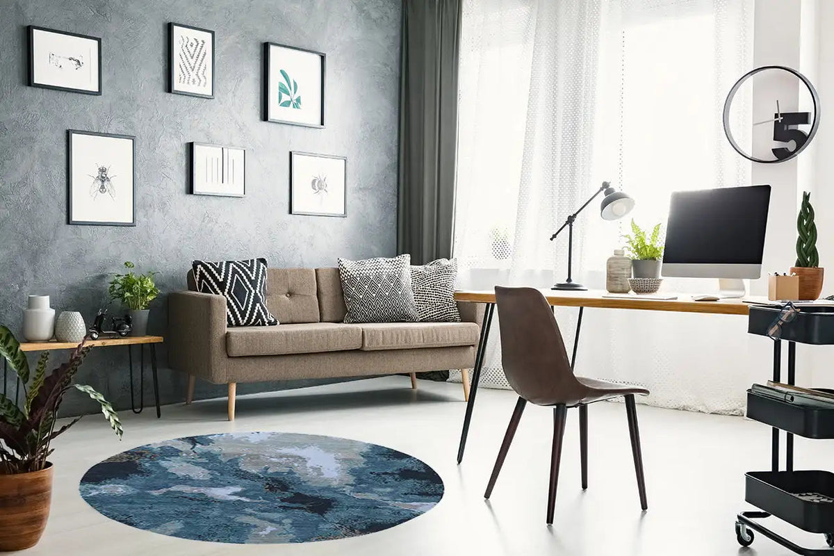 Round designer rug with an abstract blue-and-beige pattern and visible texture.