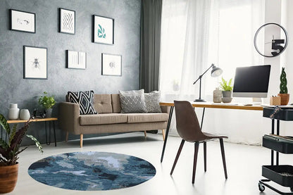 Round designer rug with an abstract blue-and-beige pattern and visible texture.