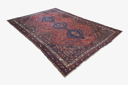 Oriental rug with a dark red central medallion and blue accents, spread out rectangularly