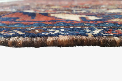 Carpet edge with dense pile and brown border, multicolored pattern in close-up detail