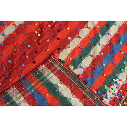 Jajim rug close-up with colorful dots, stripes, and a bound edge