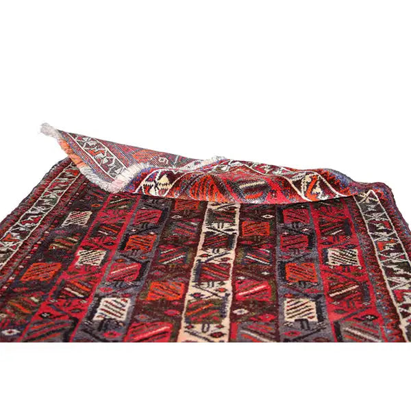 Rolled-up/laid-out rug, red and black geometric pattern with beige borders