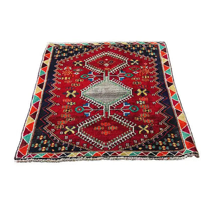 Rectangular rug with a red central medallion, geometric ornaments, and decorative border