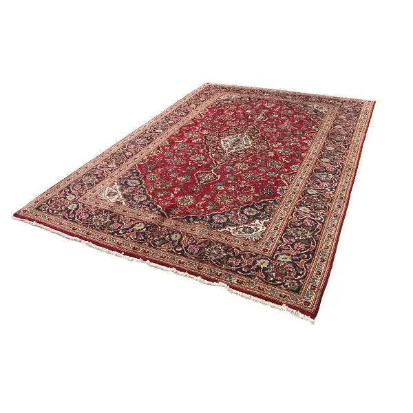 Rectangular red patterned rug with a central medallion and a colorful border.