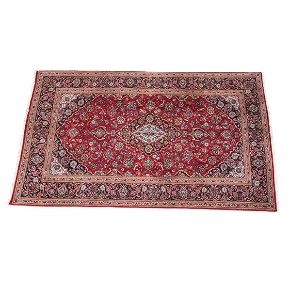 Red patterned carpet with a central field and ornamental borders, frayed carpet edge