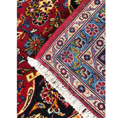 Keshan rug in red with a patterned border and white fringed edge (close-up)