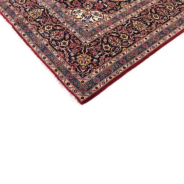Keshan carpet corner with red edges, a dark background, and a fine ornamental border