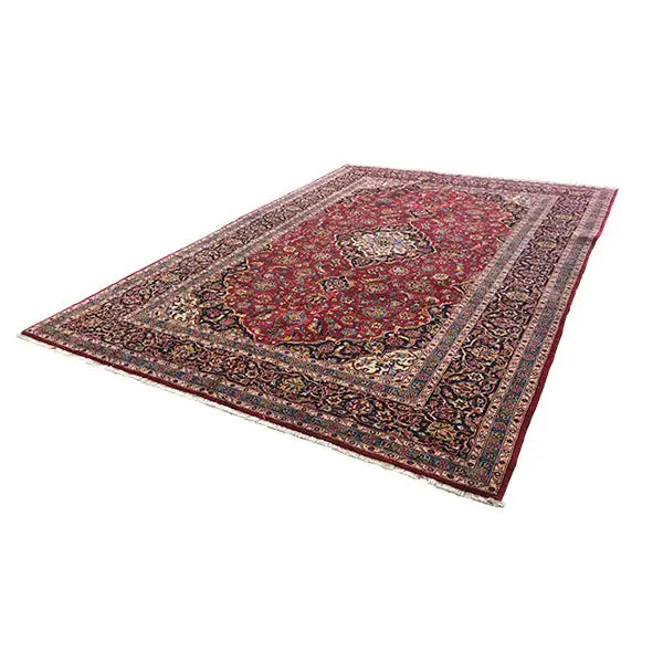 Rectangular Keshan rug in red with a textured pattern and decorative border