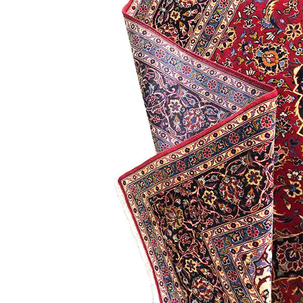Keshan rug edge detail with a border stripe in blue, red, and cream