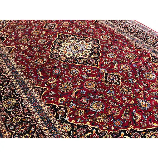 Close-up: burgundy-red carpet with a dense ornamental pattern and border