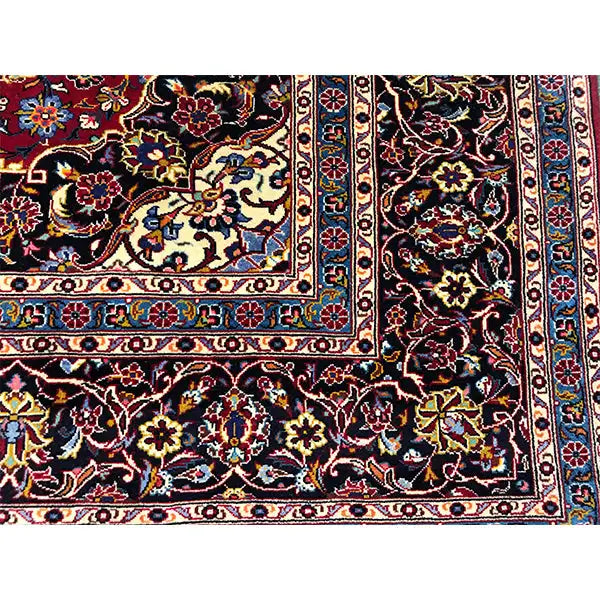 Carpet corner with a dark blue border, floral motifs, and border stripes