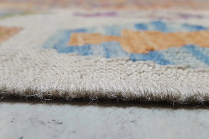 Close-up of a kilim rug at the edge with fringes and multicolored embroidered patterns