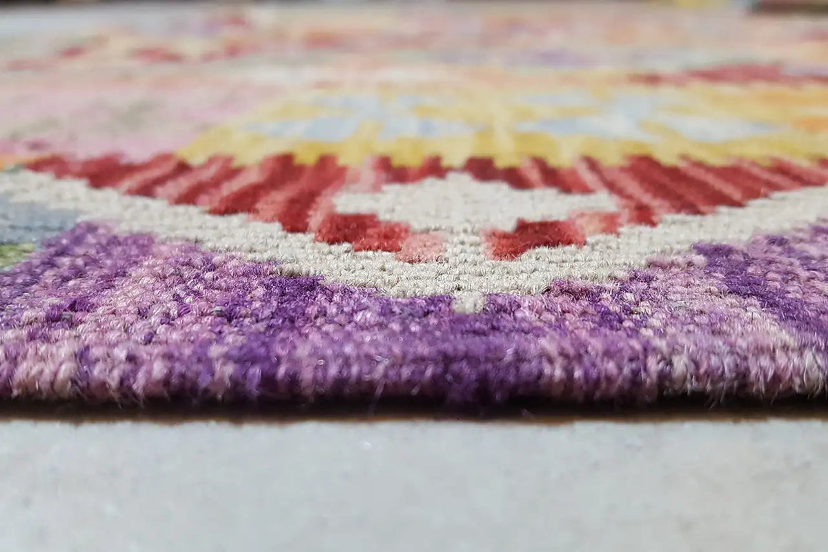 Close-up of an Afghan kilim with a short pile and purple accents along the edge
