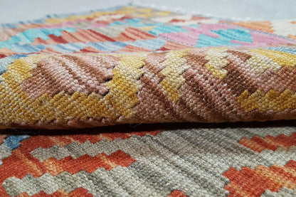Close-up of the kilim rug: densely woven, multicolored texture with relief
