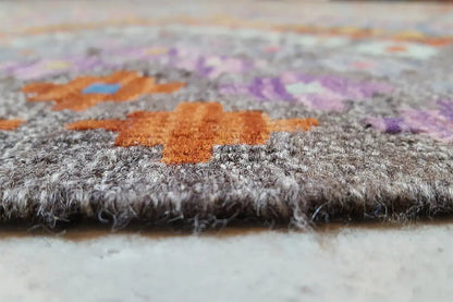 Afghan kilim detail at the edge: dense pile in gray with colorful inlays