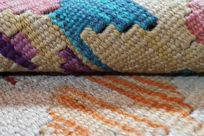 Kilim detail: multicolored fiber texture with woven diamonds and zigzag patterns
