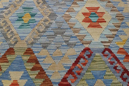 Close-up of a kilim rug with a geometric pattern in blue, red, and yellow.