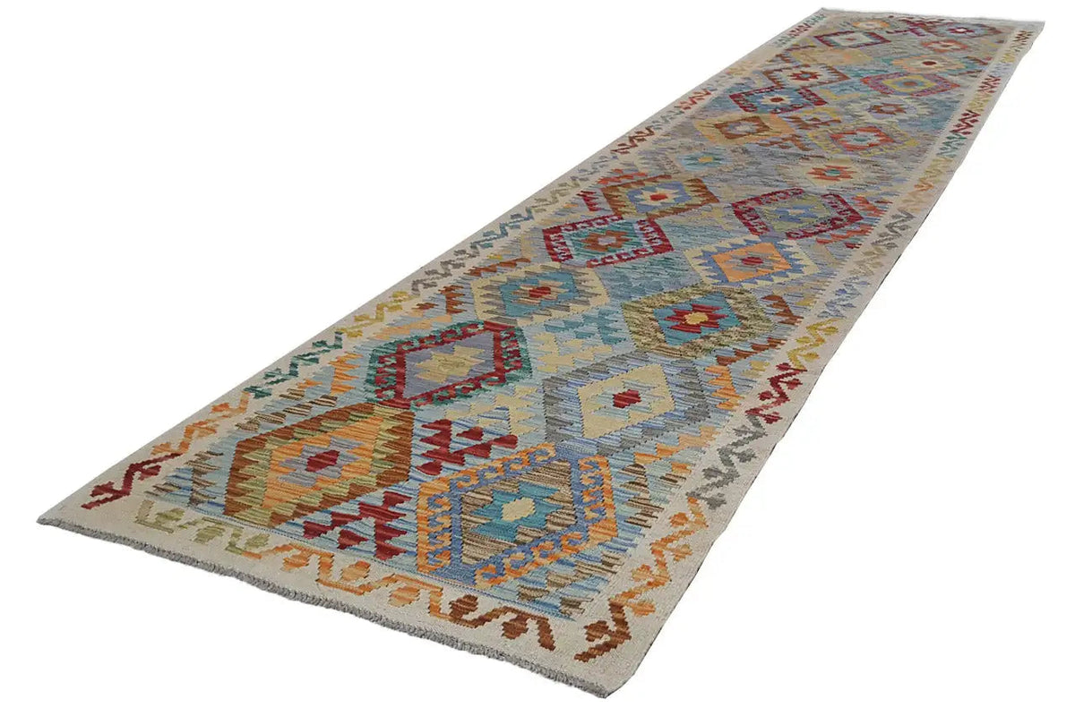 Kelim runner with a geometric pattern, light beige background with blue and red accents.