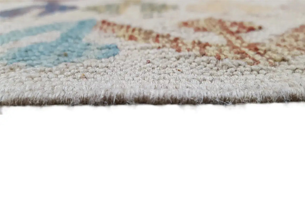 Flat-woven carpet edge with dense pile and a short fringe border, close-up view