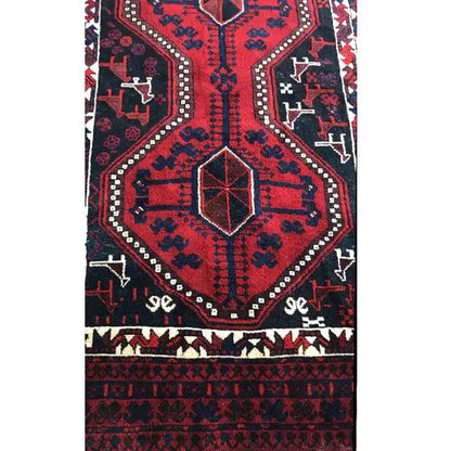 Oriental rug detail: symmetrical pattern with a central square and a narrow decorative border