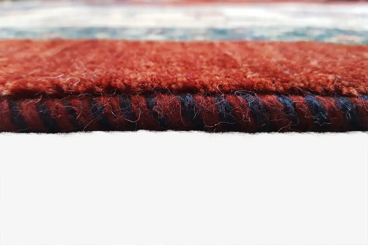 Oriental rug texture: dense pile with red and dark blue stripes along the edge