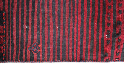 Close-up of a Bakhtiari kilim: dark blue stripes, red ornaments, and white decorative dots.