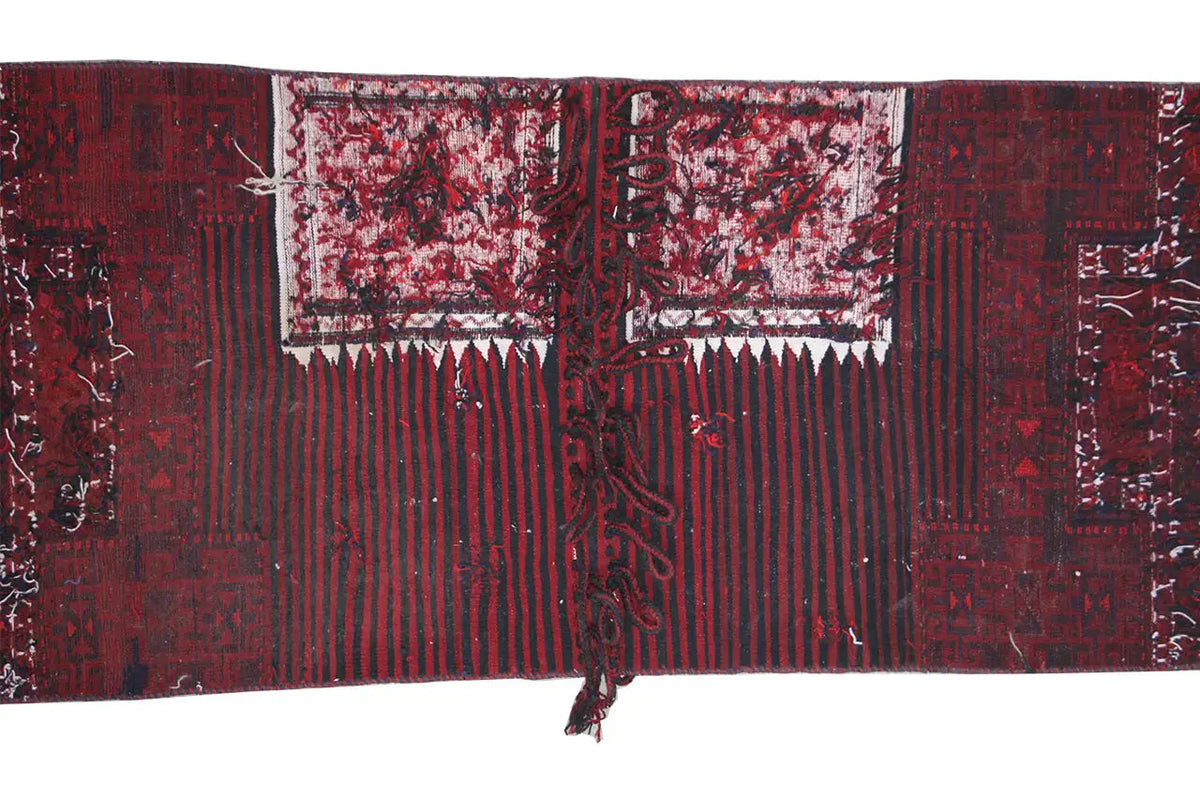 Bakhtiari kilim back view: red-black areas with lines, incorporated patterned panels.