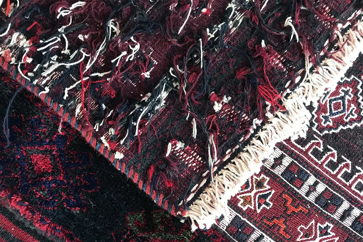 Kelim Bakhtiari rug: close-up with colorful diamonds, fringes, and bold Bordeaux highlights.