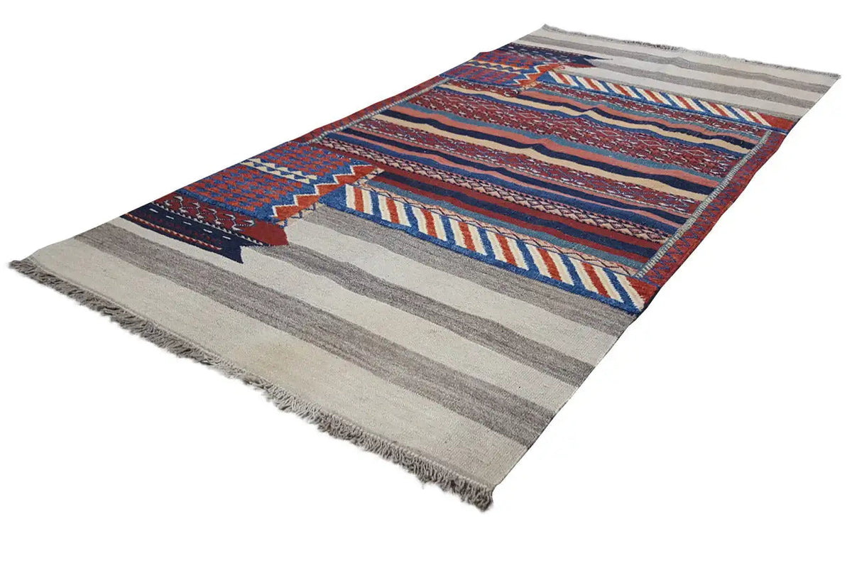 Bakhtiari kilim, shown at an angle: geometric pattern in blue, red, and beige, with fringes
