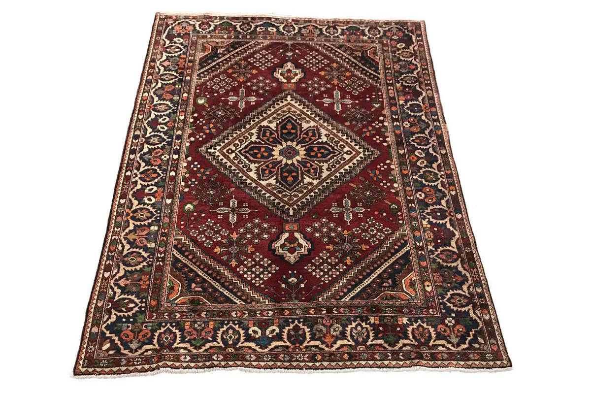 Red-brown oriental rug with a diamond medallion and decorative border, rectangular