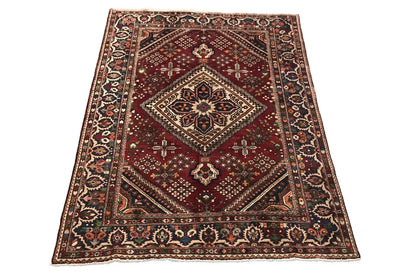 Red-brown oriental rug with a diamond medallion and decorative border, rectangular
