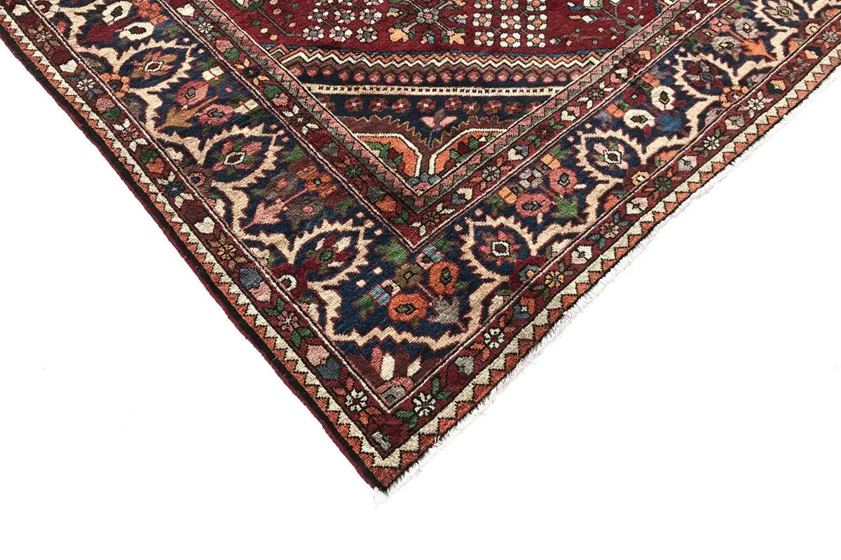 Oriental rug corner with a red background and colorful floral and diamond ornaments