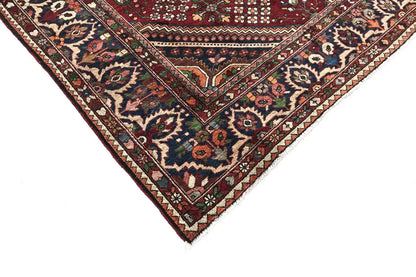 Oriental rug corner with a red background and colorful floral and diamond ornaments