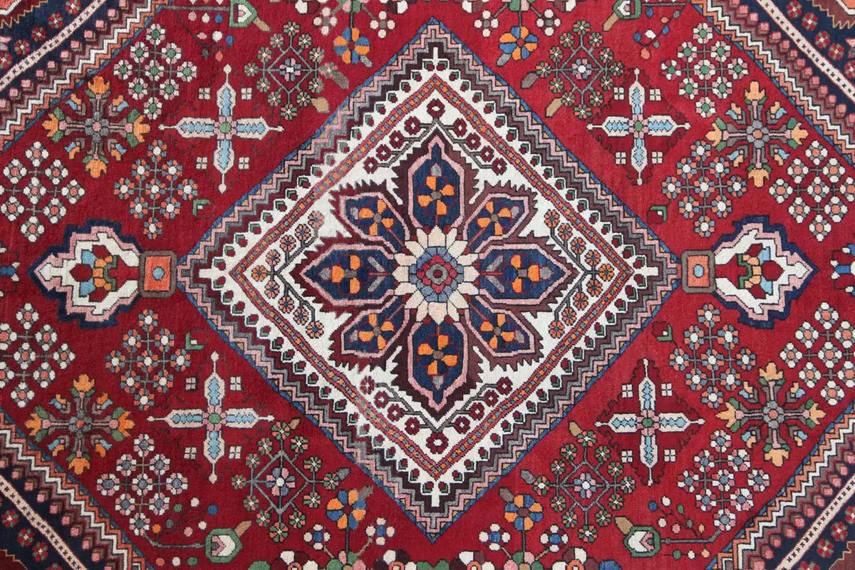 Central medallion carpet with a star-shaped design in a lozenge, on a red ground with surrounding ornaments
