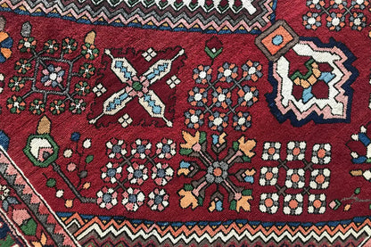 Rug: dark red diamond pattern with floral motifs and geometric border