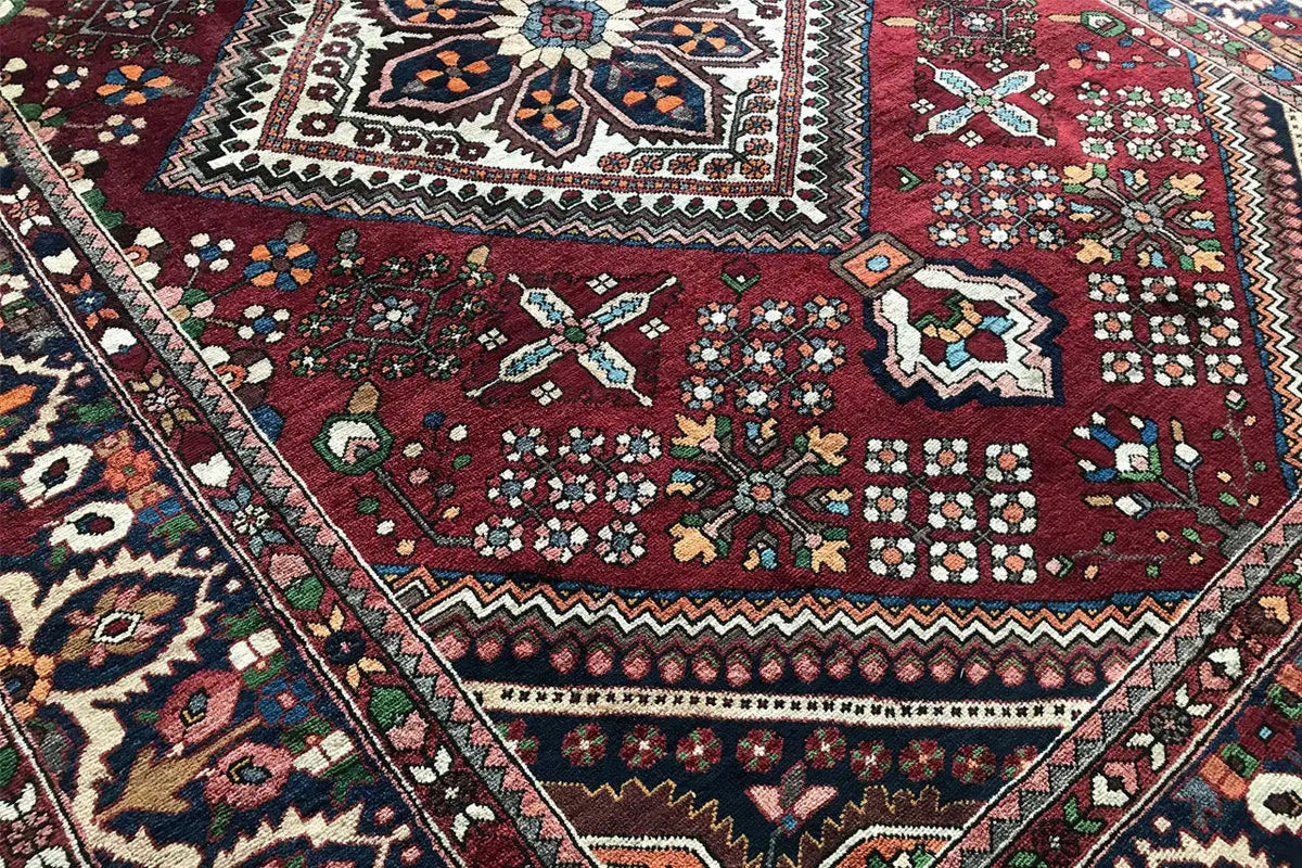 Rug: dark red field with star and diamond motifs, surrounded by a border