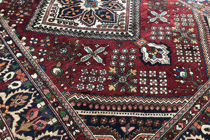 Rug: dark red field with star and diamond motifs, surrounded by a border